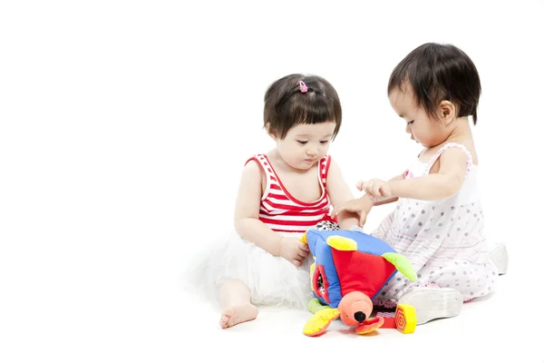 Portrait of two cute asian girls playing with toy — Stock Photo, Image