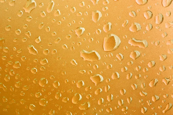 Primo piano di gocce d'acqua su superficie metallica come sfondo. Oro — Foto Stock