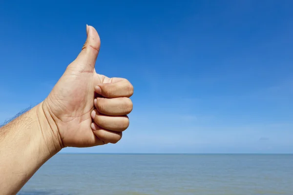 Thumb up hand sign with beach background — Stock Photo, Image