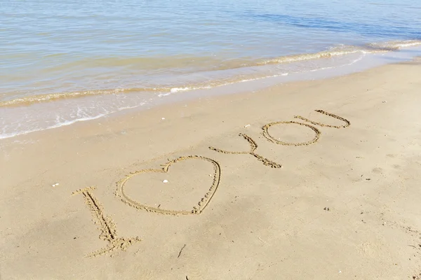 Ik hou van je in zand op strand tegen blauwe hemel — Stockfoto