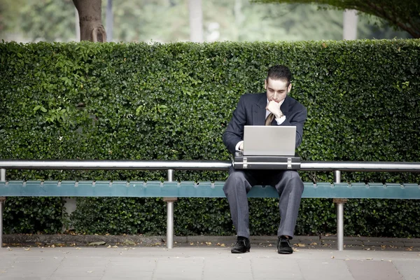 Üzletember működő laptop és várakozás-re a busz — Stock Fotó