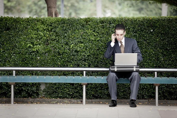 Üzletember beszél telefonon, és használ laptop — Stock Fotó