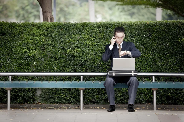 Zakenman praten over telefoon en met behulp van laptop — Stockfoto