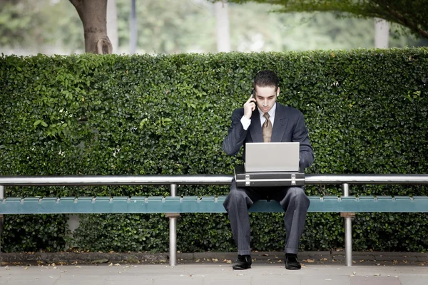 Üzletember beszél telefonon, és használ laptop — Stock Fotó