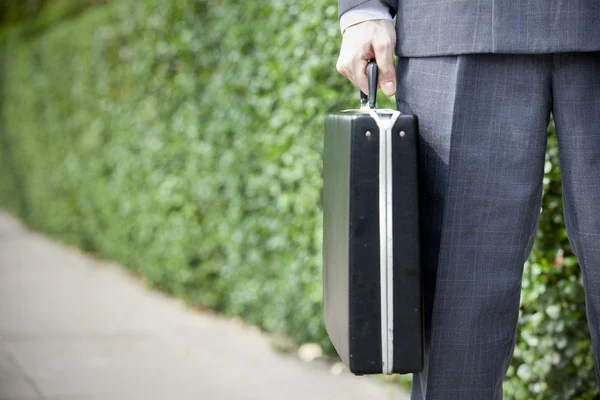 Бізнесмен стоїть з портфелем, на відкритому повітрі . — стокове фото