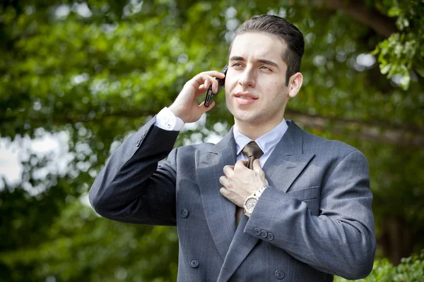 Usinessman segurando seu telefone celular contra sua orelha — Fotografia de Stock
