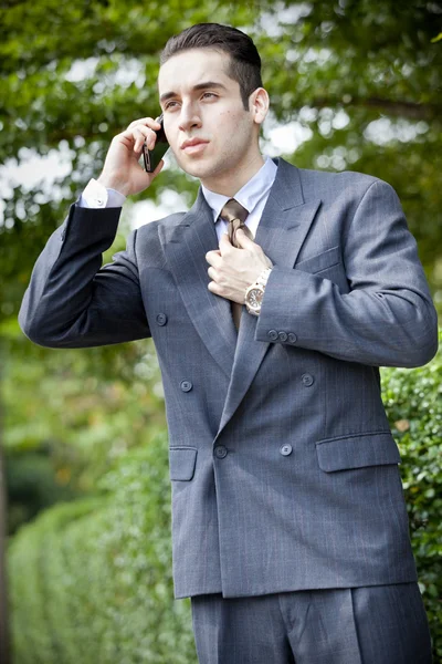 Usinessman sosteniendo su teléfono móvil contra su oreja — Foto de Stock
