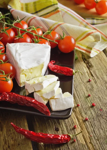 Queso en rodajas, tomates cherry y pimienta —  Fotos de Stock