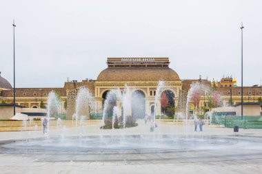 MOSCOW, RUSSIA - SEPTEMBER 19, 2021: Rusya 'da bulutlu bir sonbahar sabahı Moskova' da Paveletskaya Meydanı 'ndaki demiryolu istasyonu binasının önündeki peyzaj parkı ve çeşme