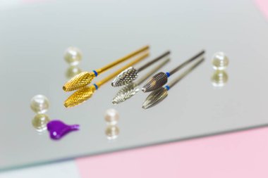 Manikür ve pedikür salonlarında inci boncuklarla süslenmiş aynanın üzerinde çivilerle çalışmak için kesilmiş bir keski seti.