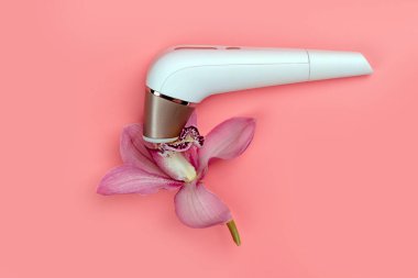 Yetişkinler için uyarıcı tatmin edici ve mercan zemininde izole edilmiş orkide çiçeği. Seks oyuncağı. Rusya, Tataristan, 28 Kasım 2021.