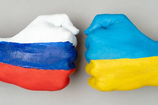 Flags of Ukraine and Russia Flag on hands punch to each others on light gray world map background, Ukraine vs Russia in world war crisis concept