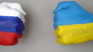 Ukrayna ve Rusya Bayrağı el ele tutuşmuş gri arka planda, Ukrayna Rusya 'ya karşı dünya savaşı kriz kavramında. Yumruklar birbirine dokunmaz..
