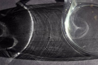 Tasarım için koyu gri soyut arkaplan, metin için alanı olan sosyal ağlar. Gri bir masanın üzerindeki cam bardağın gölgesi.