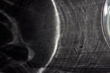 Tasarım için koyu gri ve siyah arkaplan, sosyal ağlar, metin için alan. Gri bir masanın üzerindeki camın gölgesi.