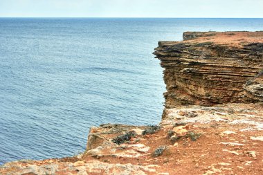 Sarı kayalık deniz kıyısı, Cliff. Mavi, derin, sakin deniz. Sakin mavi gökyüzü. Dalgalanan denizin en üst görüntüsü. Kırım 'ın batı kısmı, Tarkhankut Burnu. Güzel doğal manzara. Doğal taş deseni.
