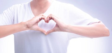 Woman making her hands in heart shape on a white isolated background. Loving the environment, protecting nature Nourishing the plants World Environment Day To help the world look beautiful.