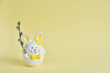 Happy Easter holiday concept, Cute bunny with pussy willow branches with catkins on white background.Springtime. Invitation card design with copy space.Selective focus