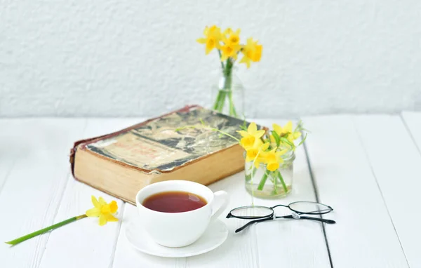 Opened Old Book Cup Tea Yellow Daffodils Light Wooden Background — Stock Photo, Image