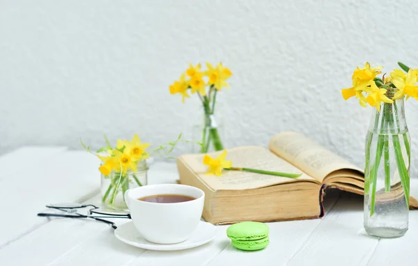 Opened Old Book Cup Tea Yellow Daffodils Light Wooden Background — Stock Photo, Image