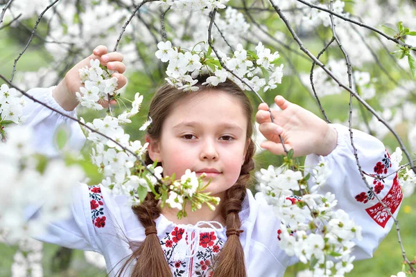 桜の庭で伝統的な刺繍のシャツを着た女の子 ハッピーイースターの日 キリスト教の伝統 スペースをコピーします — ストック写真