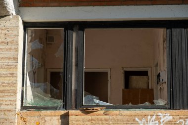 Eski bir binanın camlarında kırık camlar var. Vandallar terk edilmiş bir gökdeleni yıkıyorlar. İyi günler. Sonbahar. Rusya.