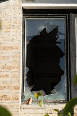 Eski bir binanın camlarında kırık camlar var. Vandallar terk edilmiş bir gökdeleni yıkıyorlar. İyi günler. Sonbahar. Rusya.