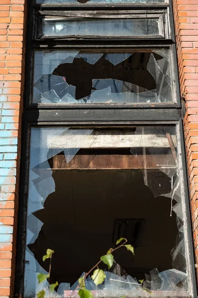 Broken glass in the windows of an old building. Vandals destroy an abandoned high-rise building. Day. Autumn. Russia.