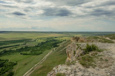 Bozkır manzarasının manzarası. Dağdan çevreye bir göz atın. Tarlalar, yollar, köyler, kuş bakışı dağlar. İyi günler. Yaz. Rusya.