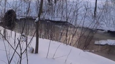 Buzlu bir nehirde temiz su. Parkta donmuş su, buz ve kar var. Kış. - Rusya. Gün.