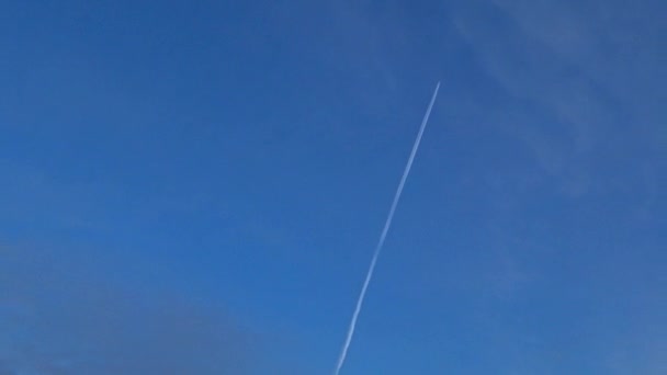 飛行機は青い空を高く飛んでいる 飛行機は霜の多い冬の空に白い歩道を残します ロシアだ — ストック動画