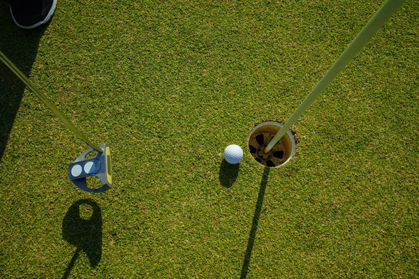 ゴルフ練習の練習は 緑の上にゴルフボールを置きます 夕方に設定された時間にレンズフレア — ストック写真
