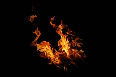  Siyah arka planda yangın alevleri. Soyut yangın arka planı. Ateşteki ateş geceleri doğal olarak el salladı..                               