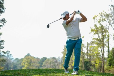 Akşam golf sahasında golf oynayan bir golfçü. Güneşin altında golf oynayan bir adam..                                   