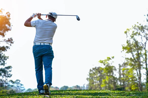 Akşam golf sahasında golf oynayan bir golfçü. Güneşin altında golf oynayan bir adam..                                   