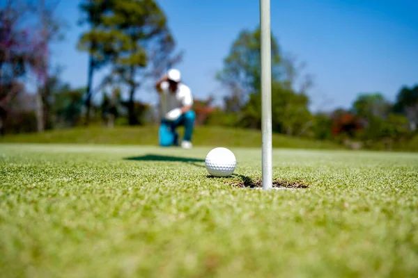 Akşam golf sahasında golf oynayan bir golfçü. Güneşin altında golf oynayan bir adam..                                 