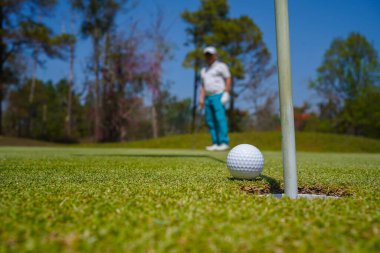 Golf topları gün batımında golf sahasında golf oyuncuları tarafından delik deşik edilecek. Golfçüler akşam saatlerinde golf sahasına golf oynuyorlar..                               