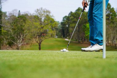 Akşam golf sahasında golf oynayan bir golfçü. Güneşin altında golf oynayan bir adam..                             