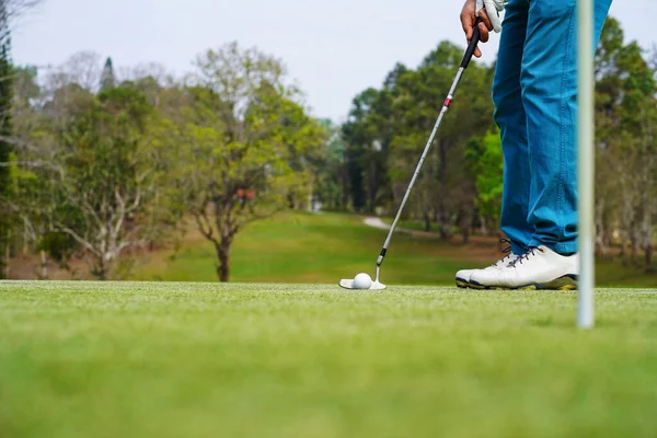 Akşam golf sahasında golf oynayan bir golfçü. Güneşin altında golf oynayan bir adam..                             