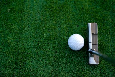 Golf sopaları ve golf topları yeşil çimlerde sabah güneşli güzel bir golf sahasında. Golf sahasındaki delikte bir top..                               