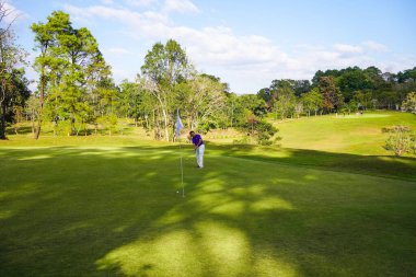Bulanık golfçü akşam vakti golf sahasında golf oynuyor. Güneşin altında golf oynayan bir adam..                                   