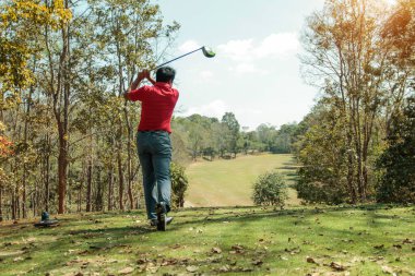 Golfçü golf oynuyor ve yeşil çimen dağ arka planına vuruyor. Asya 'lı erkek oyuncu yazın vuruldu. Spor tatil yaşam tarzı konsepti.