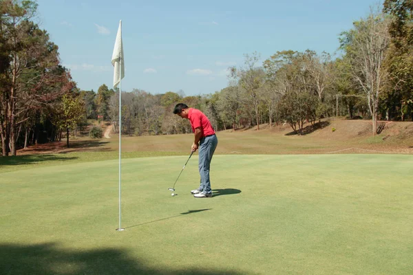 Golfer are playing game golf and hitting go on green grass mountain background. Asia male player game shot in summer. Sport holiday lifestyle concept.