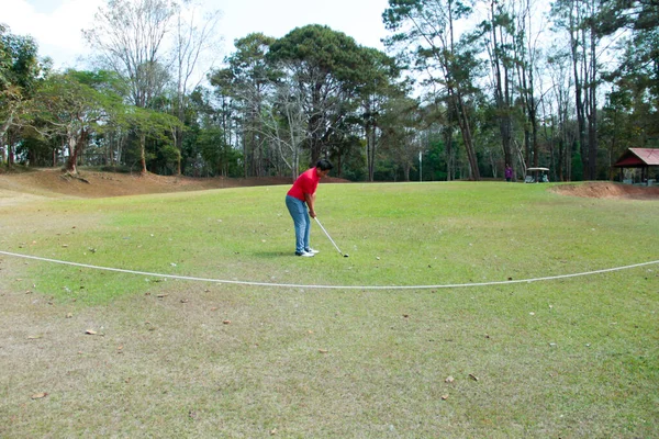 ゴルファーは ゲームゴルフをプレイしていると緑の草の山の背景に行く打撃 アジアの男性選手のゲームは夏に撮影した スポーツの休日のライフスタイルコンセプト — ストック写真