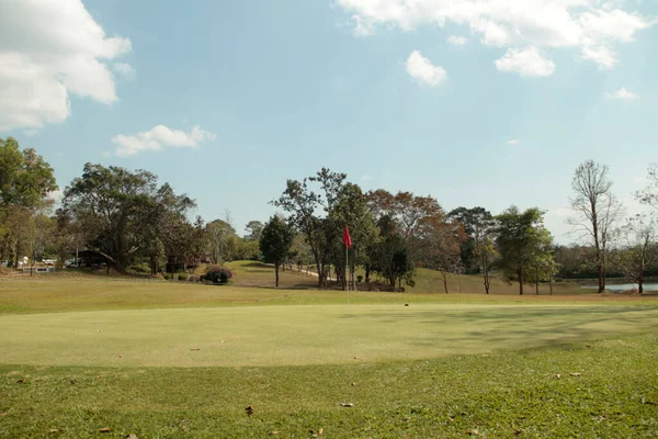田舎の夕日で美しいゴルフコースの風景 日の出時のゴルフ場の赤い旗 — ストック写真