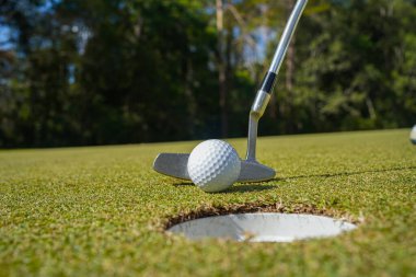 Golf sopaları ve golf topları yeşil çimlerde Sabah güneşli güzel bir golf sahasında.                               