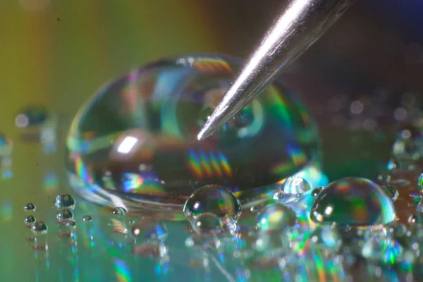 Pencil slate touches the surface of a drop of water close-up