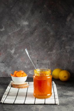 Cam kavanozda havuç reçeli ve beyaz bir peçetede doğranmış havuç.