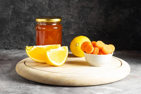 Cam kavanozdaki tatlı havuç reçeli ahşap bir büfede malzemelerle birlikte.