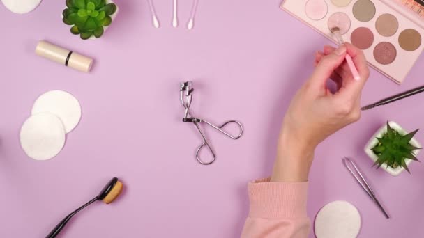 Mano Una Joven Recoge Sombras Pestañas Con Pincel Sobre Fondo — Vídeo de stock